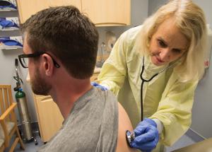 Doctor listening to patient heartbeat with stethoscope