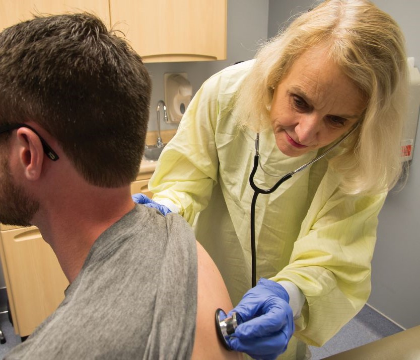 doctor using stethoscope on patient
