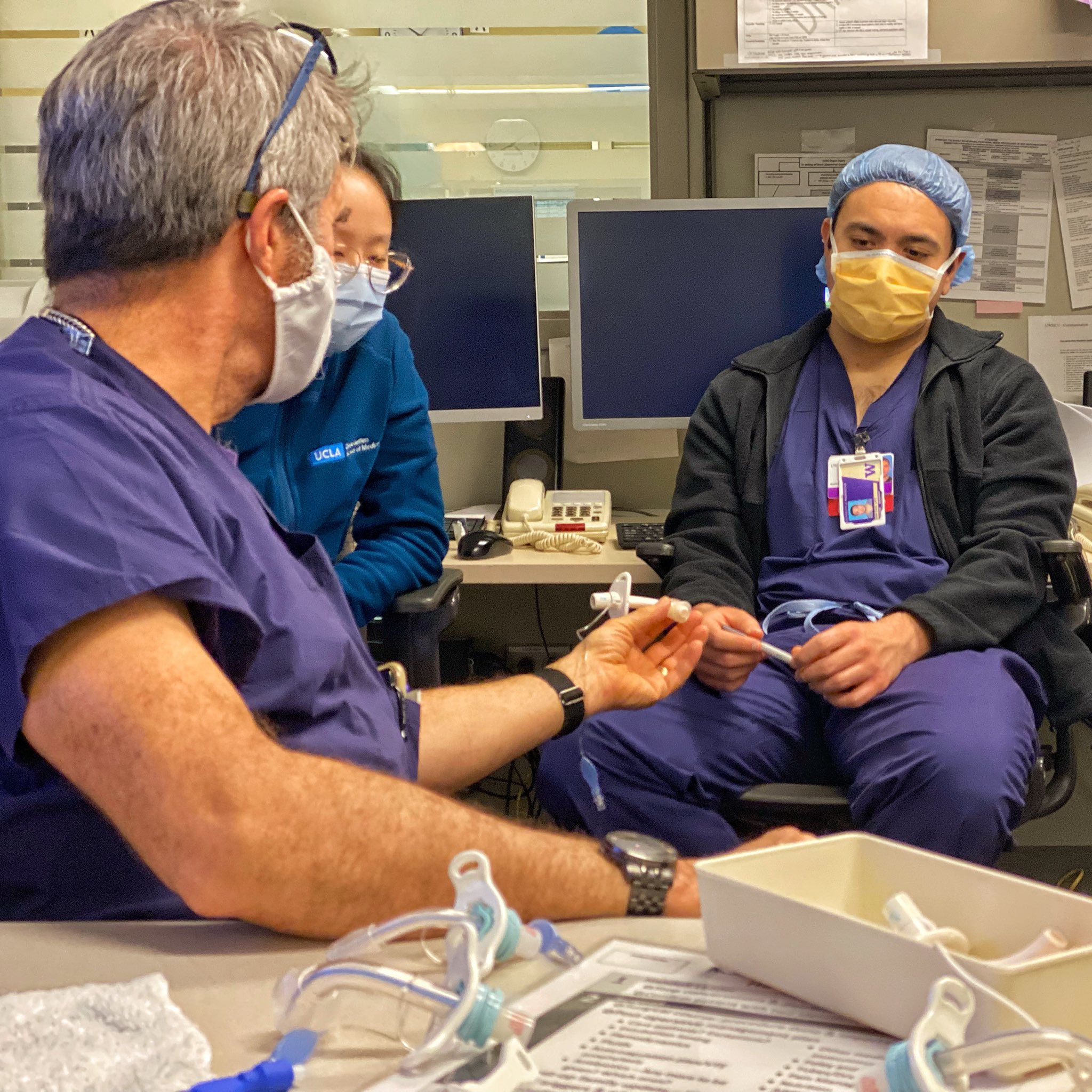 Faculty and fellows in scrubs with teaching model